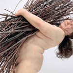 Scultura iper realistica di donna con rami
