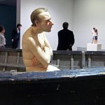 Scultura di uomo nudo seduto in barca